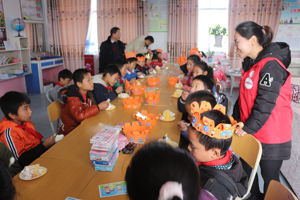 20171211112154467812.bmp 生日会上留守儿童在开心地吃着蛋糕.bmp